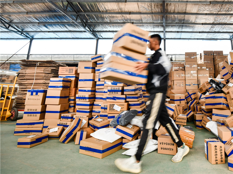 河北省玉田县鸦鸿桥镇一座电商物流仓库的工作人员在搬运待发货的产品。
