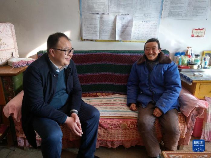邱军（左）在乔川乡村民家中宣讲扶贫政策（2019年1月25日摄）新华社发