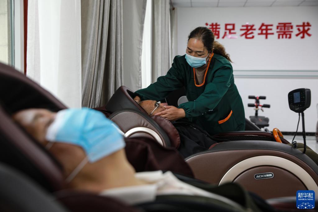 9月3日，在甘肃甘南夏河县拉卜楞综合社会福利中心，护理人员帮助老人做按摩。新华社记者 冯亚松 摄