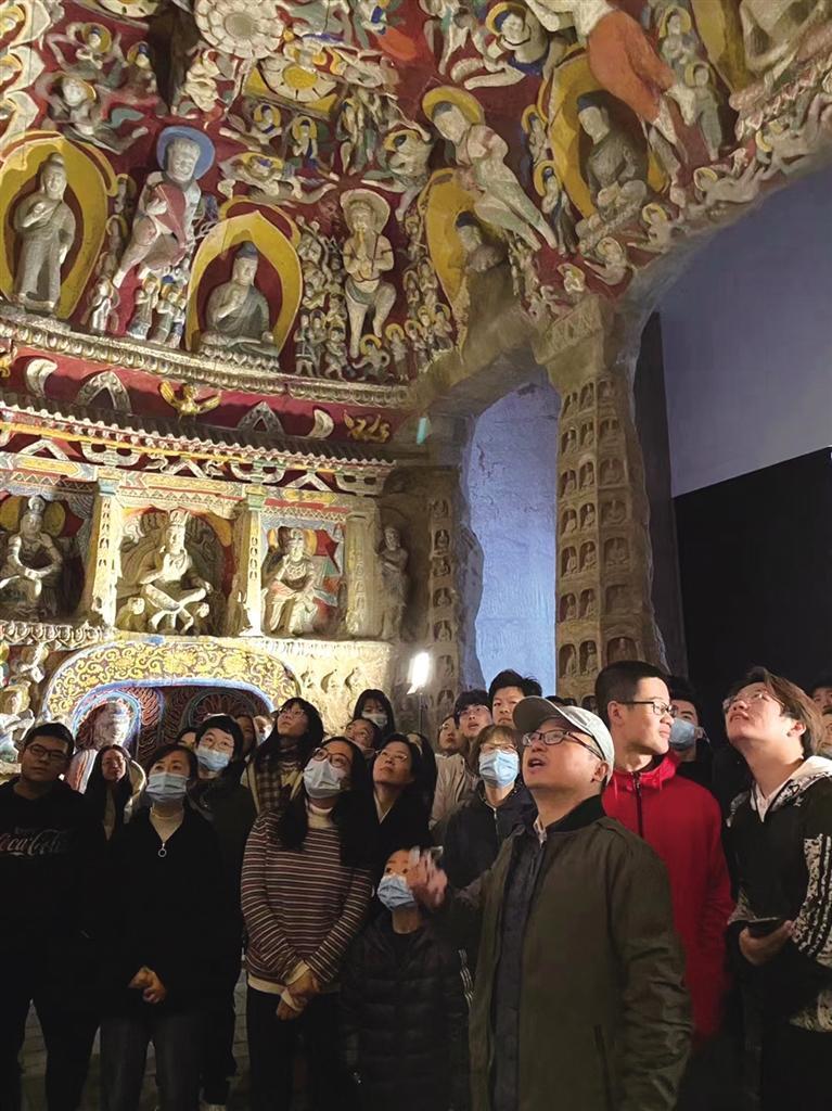 在石窟给学生讲课