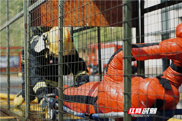 消防员正模拟从狭小空间搬运假人。