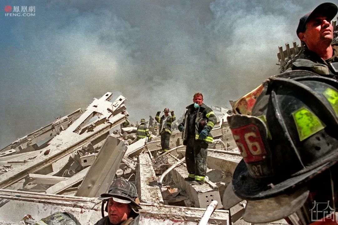 消防员站在南塔的废墟上,按照救火时传递水桶的队形,搜救着幸存者