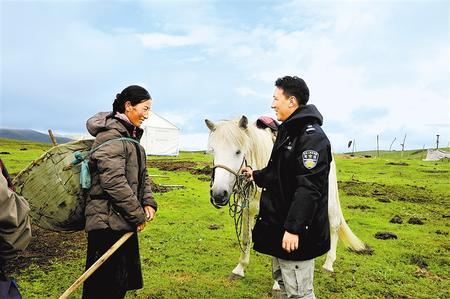 欧拉秀玛乡马背普法宣传队队长加羊才旦和群众交谈