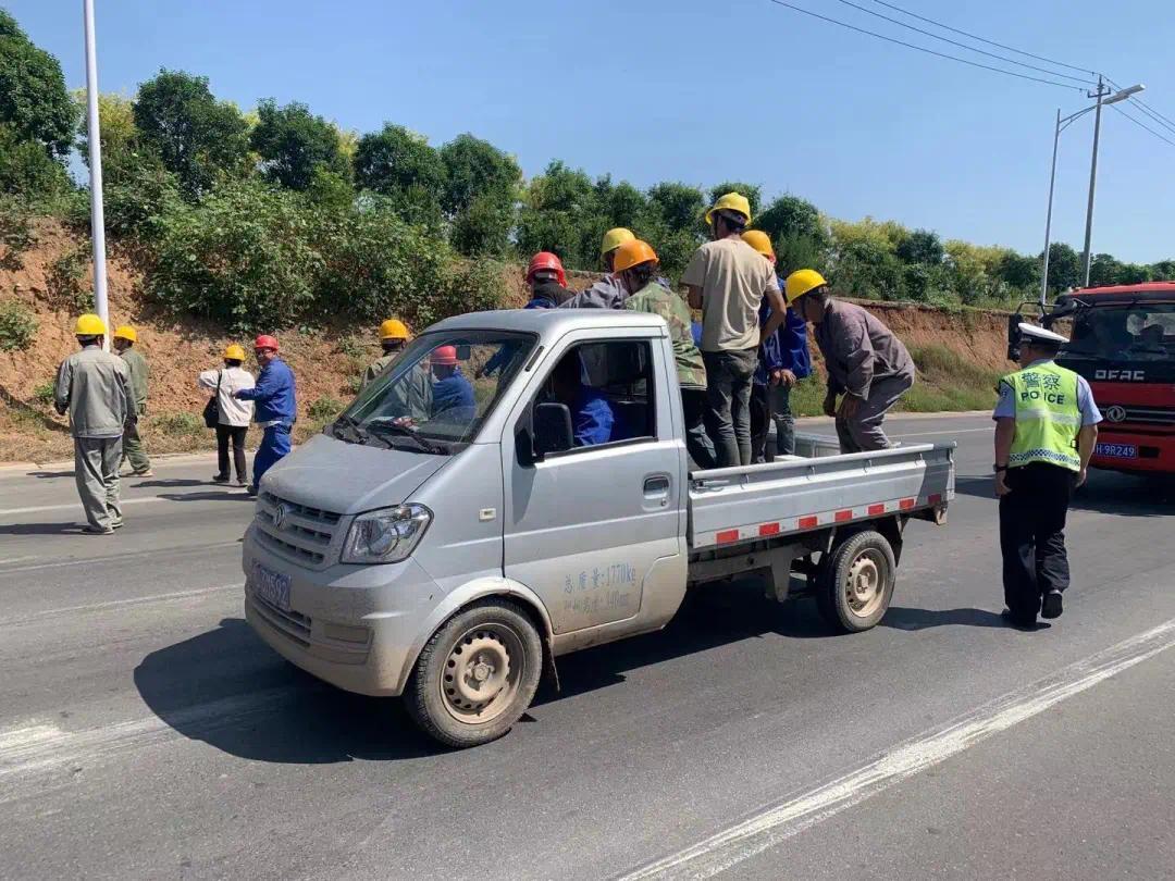 发现一辆轻型栏板货车后车厢内然密密麻麻蹲坐满了戴头盔的务工人员