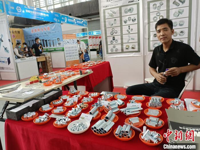 图为展览会上，一名参展商展出不同型号的标准件。　王天译 摄