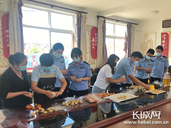 民警和社区居民共同学习制作月饼。