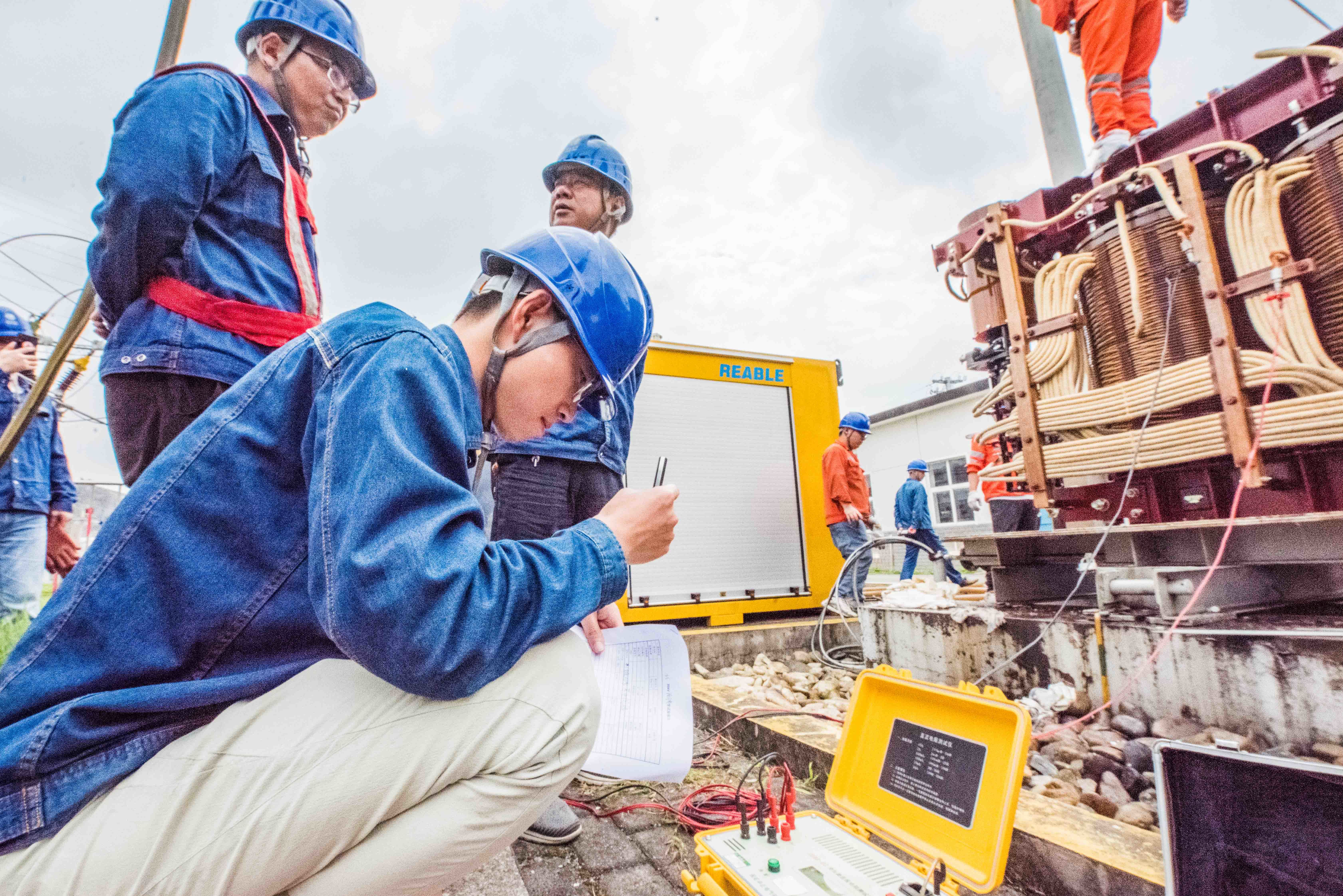 图为庐江县供电公司员工对1号主变开展实验测试