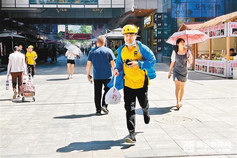 外卖小哥在烈日下飞奔送餐 (西安报业全媒体记者 郝钟毓 摄)
