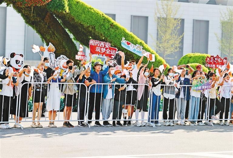 9月12日，十四运会火炬传递中，热情的市民加油助威。（西安报业全媒体记者 谢伟 摄）