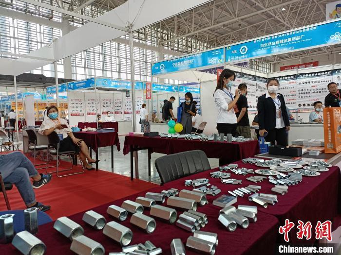 图为展览会上，一名参展商展出不同型号的标准件。　王天译 摄