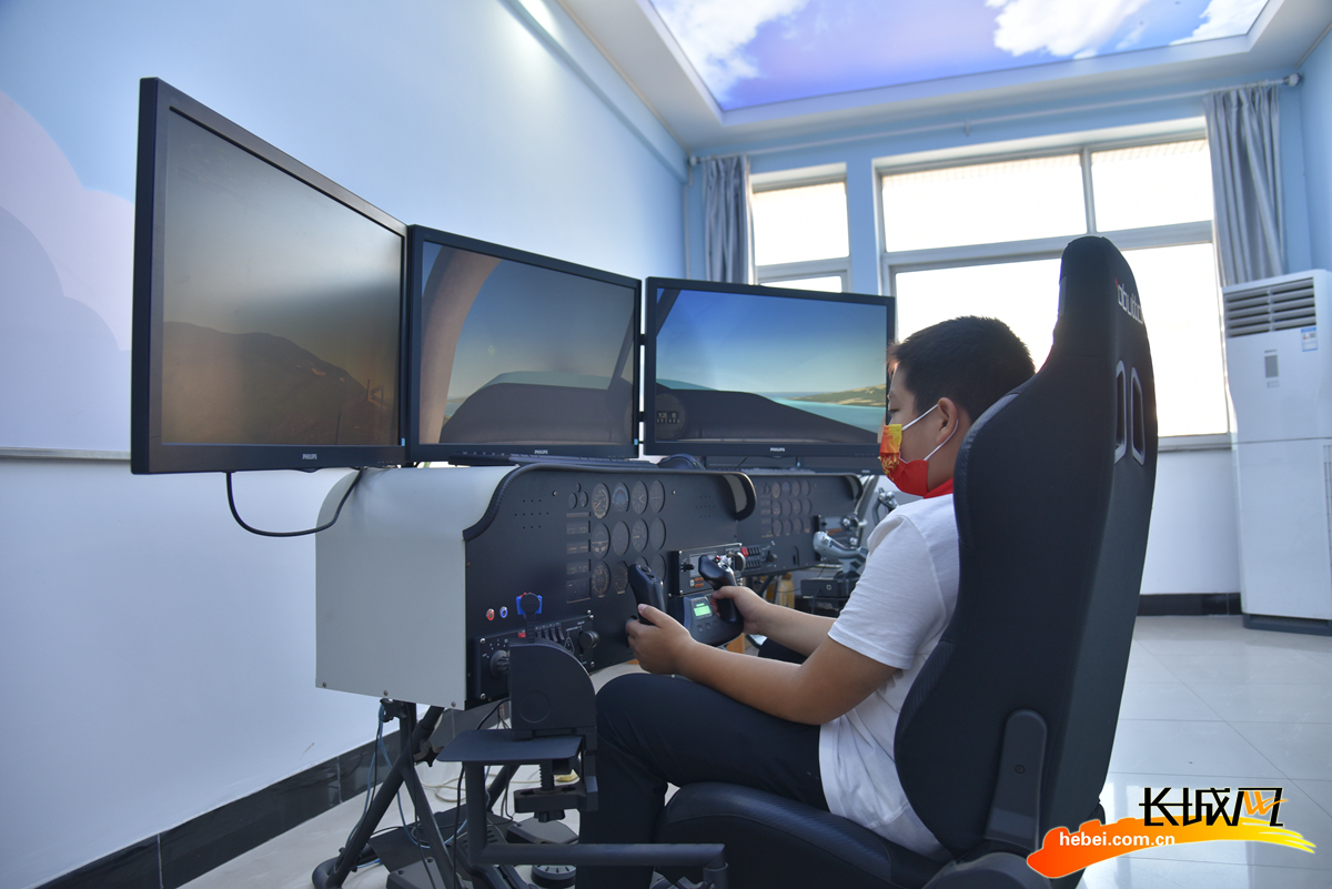 一名学生在活动现场体验飞机模拟驾驶.