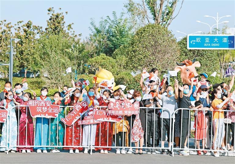 欧亚大道旁的市民为火炬手欢呼助威。 （西安报业全媒体记者 谢伟 摄）