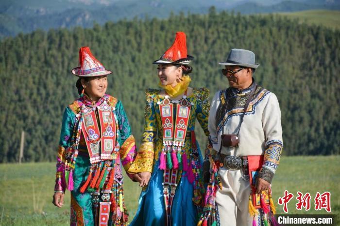 图为玛尔健(中)与阿扎阿娜(爸爸妈妈)去甘肃省张掖市肃南县康乐草原看赛马会。(资料图) 玛尔健供图