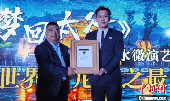 上海大世界基尼斯颁证官陈鸣捷（右）向恋乡&middot;太行水镇艺术总监颁发证书。　徐巧明　摄
