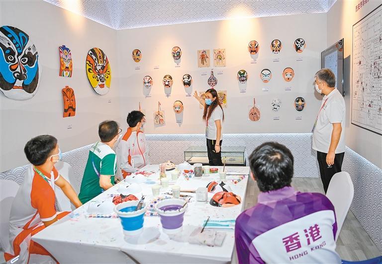 九月二十日，工作人员为陕西、香港、澳门代表团成员介绍陕西脸谱文化。 （新华社记者 孙非 摄）