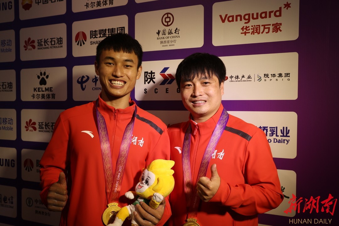 龙金宝（左）与教练赛后共享冠军荣耀。 湖南日报·新湖南客户端记者 唐俊 通讯员 陈杰 摄