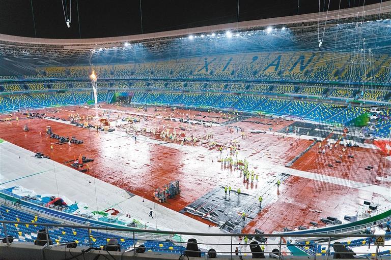 开幕式结束后，工作人员冒雨进行场地转换。西安奥体中心供图