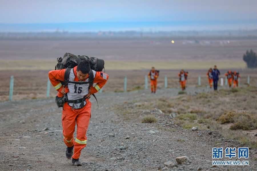 一名参赛队员正在戈壁滩上负重奔跑 新华网发(龙智祥 摄)