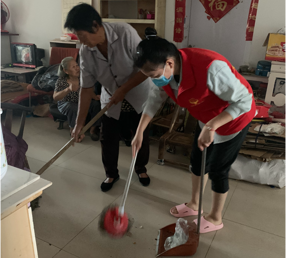 图为社工师与物业人员为困难儿童家庭打扫卫生的情景