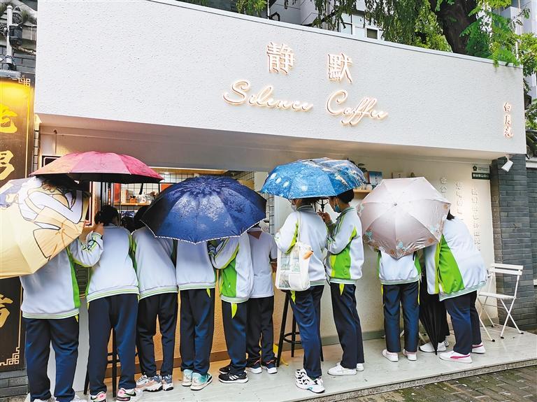 雨中,学生们和他们手中的雨伞成了老街巷里的风景。