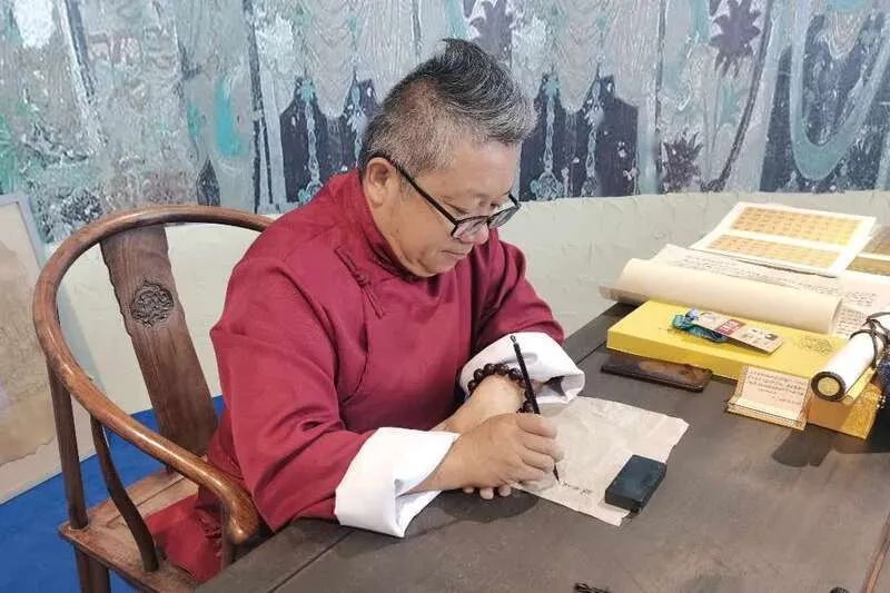 图注：朱建斌正在写经