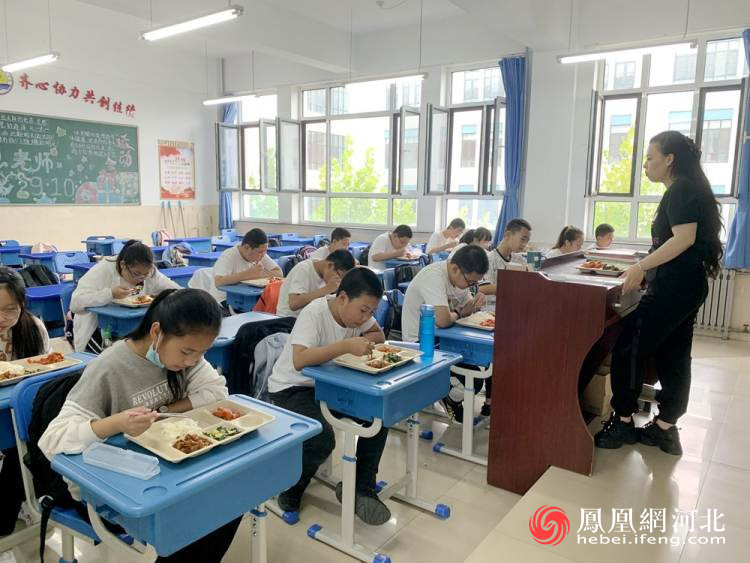 图为开发区第四中学教师同学生一起吃午餐。