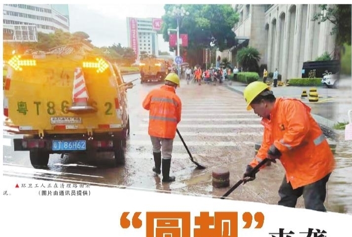 环卫工人正在清理路面淤泥。