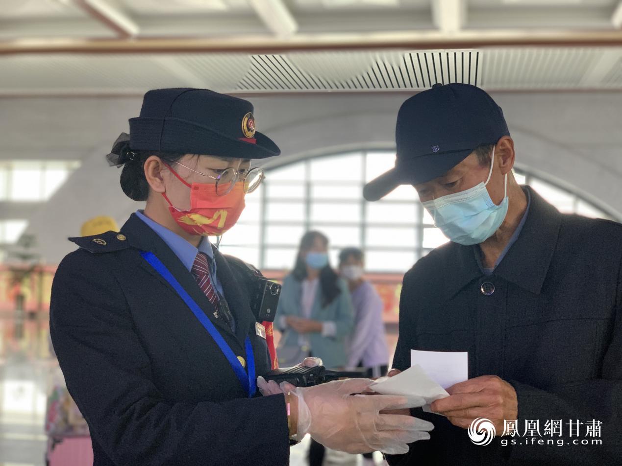 车站工作人员为老年旅客确认车票信息 吕金菊 摄