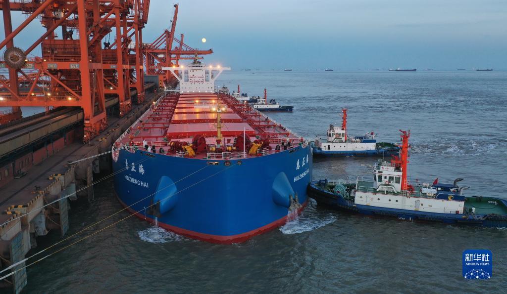 10月20日，一艘轮船在拖轮的协助下向唐山港曹妃甸港区矿石码头靠泊（无人机照片）。