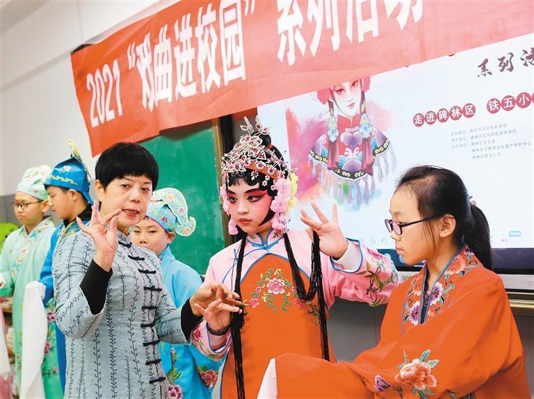 小学生在老师指导下体验戏曲表演 记者 尚洪涛 摄