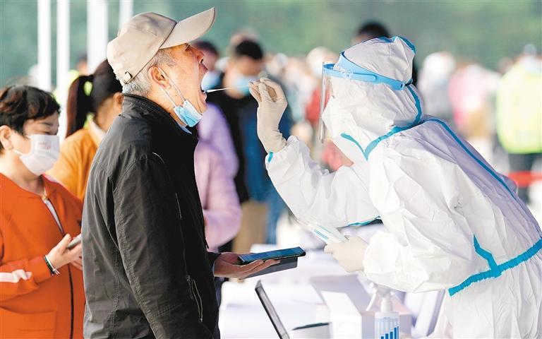 10月19日,市民在西安市曲江池遗址公园外一核酸检测点进行核酸检测