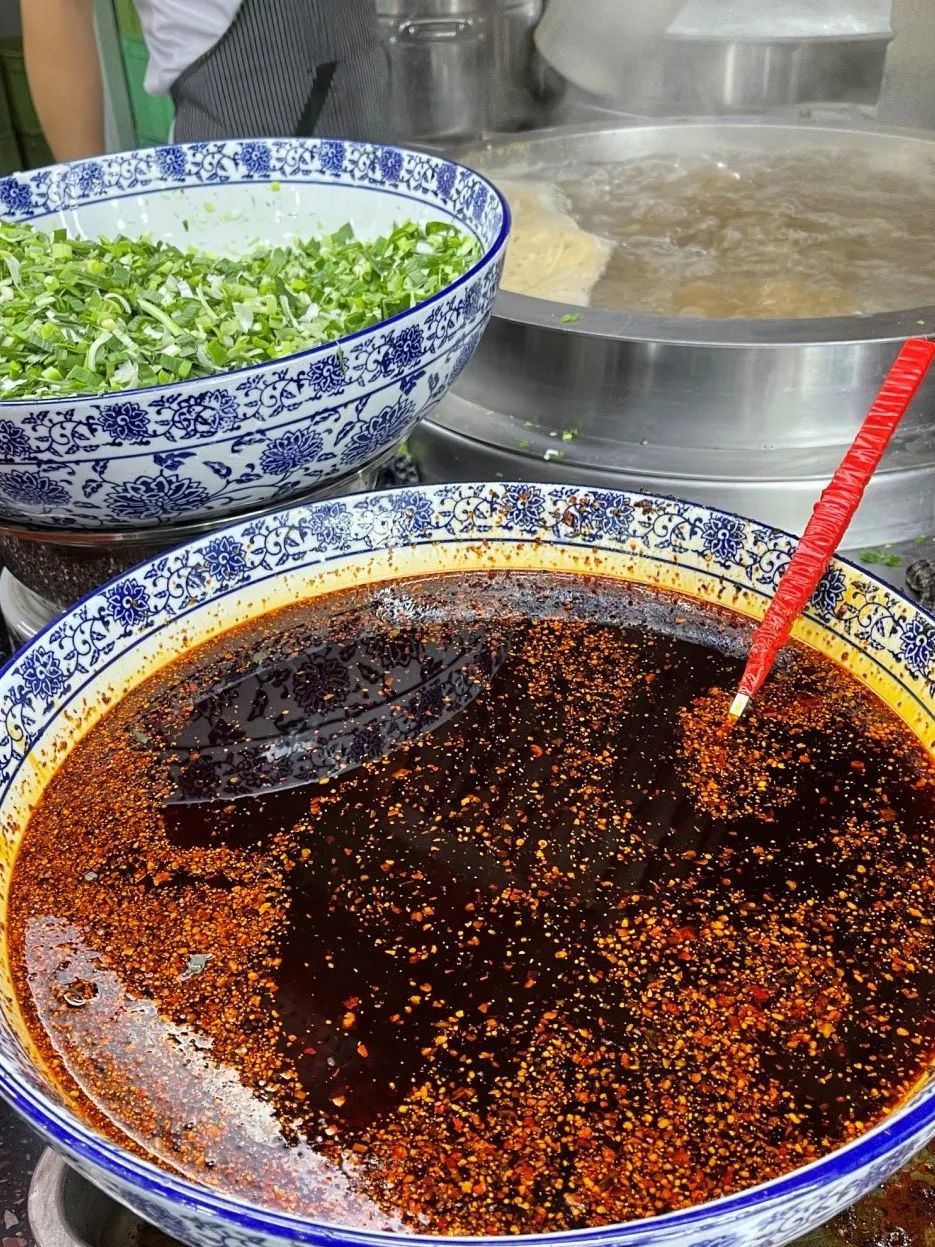 ▲ 汤锅旁边，就是满满一大盆辣子，调完辣子，面就可以闪亮登场了。摄影/砍柴书生