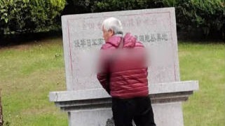 老人在南京大屠杀丛葬地纪念碑上小便