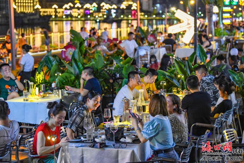 近日,在海口外滩绅士音乐餐吧,市民游客坐在富有情调的外场,品味精致