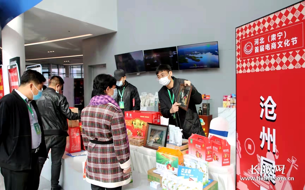河北（肃宁）首届电商文化节现场，员工在展区内展示商品。