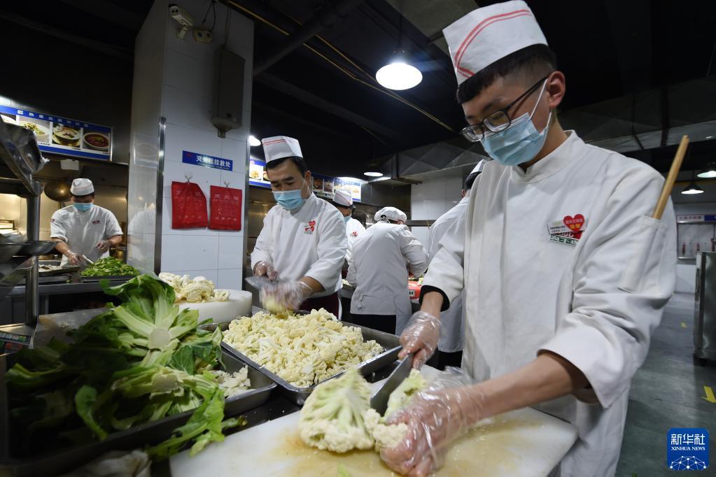 10月25日,在兰州市城关区一餐饮企业,工作人员在制作隔离人员餐食。新华社记者 范培珅 摄