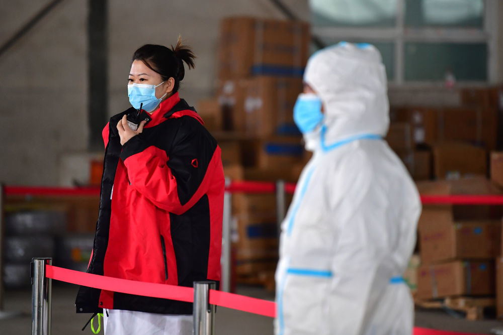 佟锦媚（左）在“猎鹰号”硬气膜实验室外用对讲机与舱内同事联系（10月26日摄）新华社记者 陈斌 摄