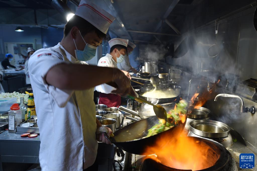 10月25日,在兰州市城关区一家餐饮企业,工作人员在制作隔离人员餐食。新华社记者 范培珅 摄