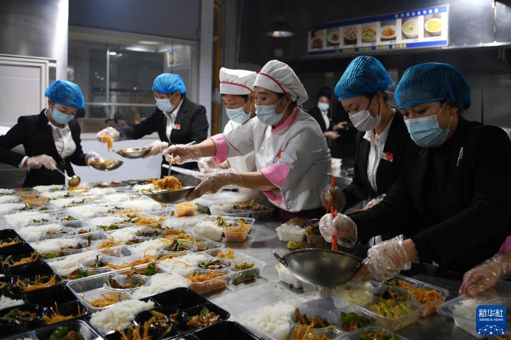 10月25日,在兰州市城关区一家餐饮企业,工作人员在给隔离人员分装菜品。新华社记者 范培珅 摄