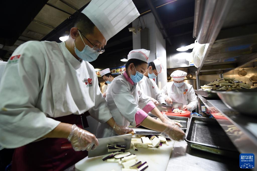 10月25日,在兰州市城关区一餐饮企业,工作人员在制作隔离人员餐食。新华社记者 范培珅 摄