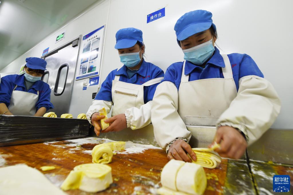 10月26日,在兰州市安宁区一家餐饮集团的中央厨房,工作人员在制作花卷。新华社记者 范培珅 摄