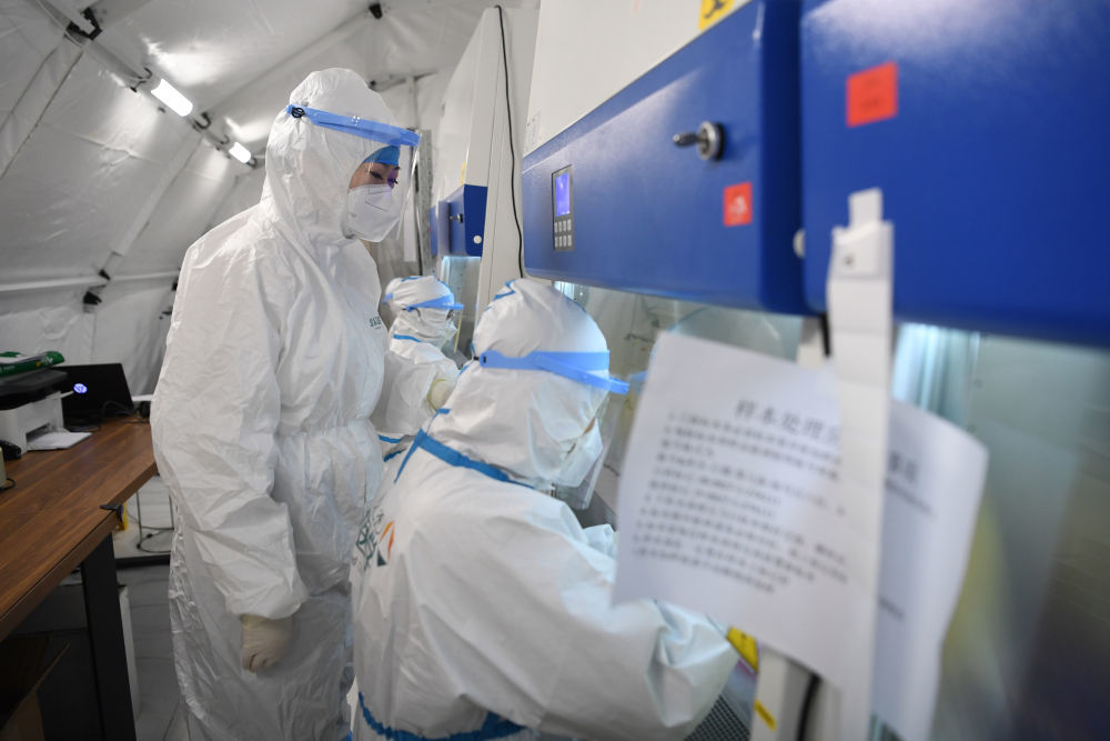 佟锦媚（左）在“猎鹰号”硬气膜实验室样本处理区工作（10月26日摄）新华社记者 陈斌 摄