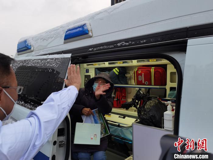 图为出院患者与医生挥手告别。　张婧 摄