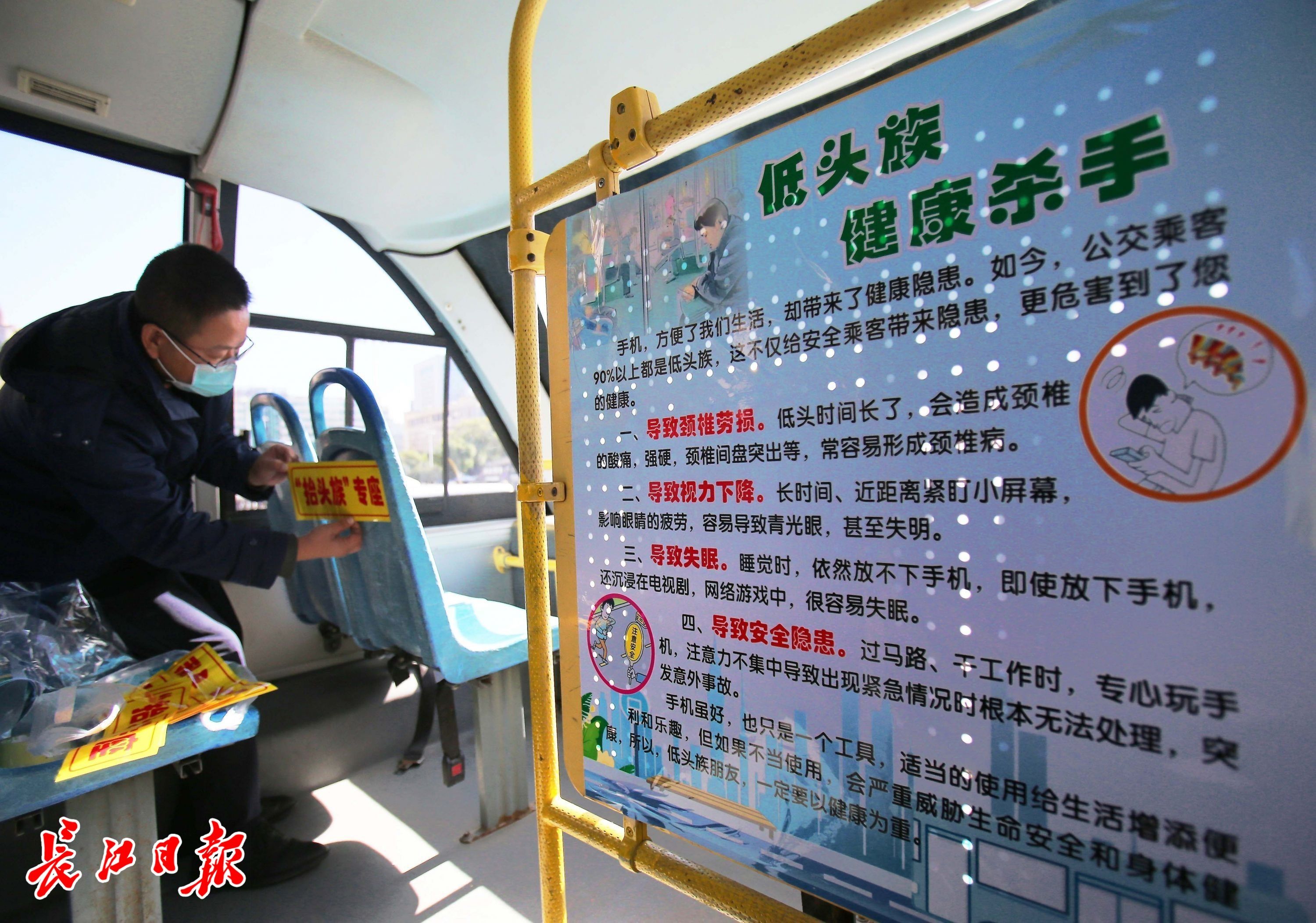 作人员正在张贴“抬头族”专座标识。长江日报记者张宁 摄