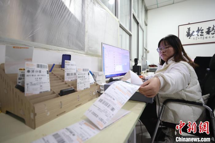 霸州市信安镇一家具公司内，客服人员正在打印发货单。　贾珺 摄