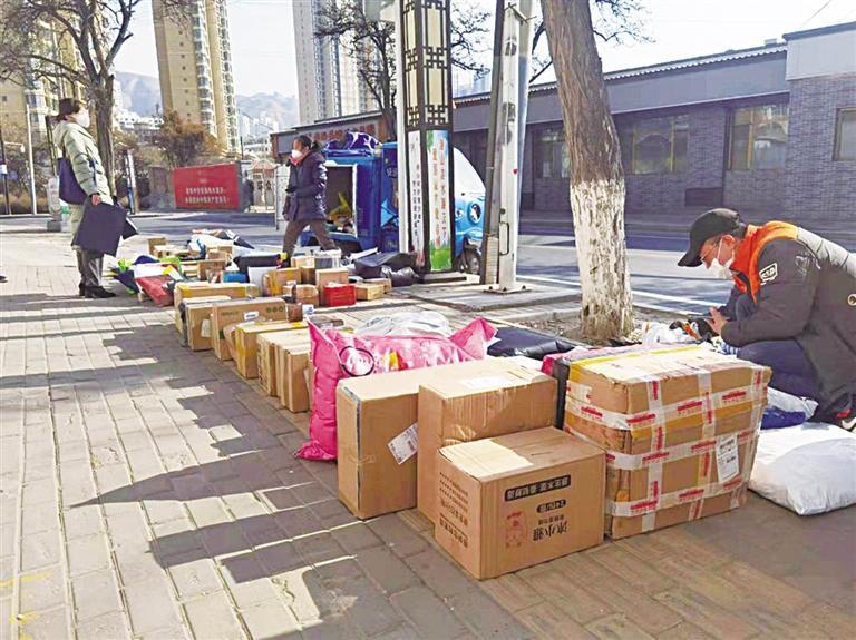 安宁区十里店附近，快递员们正在联络市民取快递。