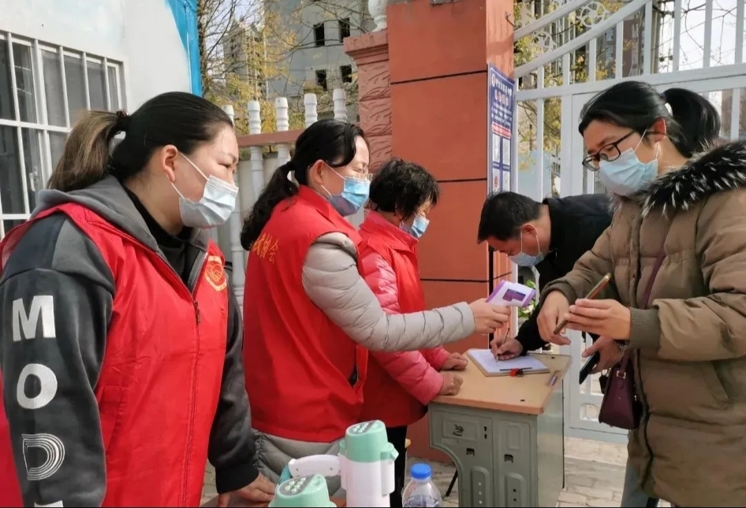 学校工作人员和志愿者为前来健身的市民测量体温,扫码登记.张珂 摄