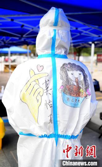 在江西省上饶市铅山县河口镇文化广场，做完核酸检测的医护人员正在防护服上画上各种各样的美图。　丁铭华 摄