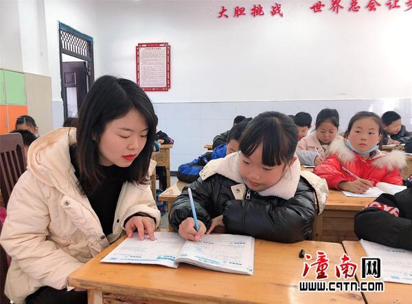 赴彭水交流的青年教师聂孝桃，正在教室辅导学生作业。