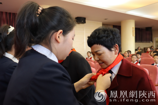 少先队员为与会领导佩戴红领巾